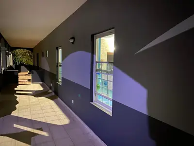 a hallway with a purple wall and a window at Djabraba's kaminhu Double in Vila Nova Sintra