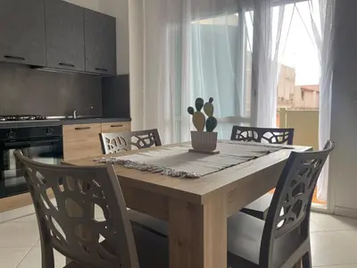 a kitchen with a wooden table with chairs and a cactus at Soul of Sal in Santa Maria