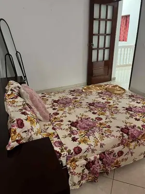 a bed with a floral comforter in a room at MONTROND House in São Filipe