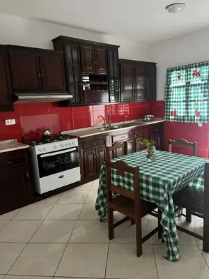 a kitchen with a table with a green and white table cloth at MONTROND House in São Filipe