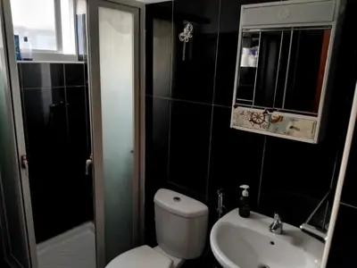 a bathroom with a white toilet and a sink at Gada House in Sal Rei