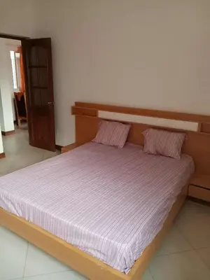 a bedroom with a large bed with a wooden headboard at Gada House in Sal Rei
