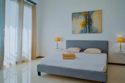 a bedroom with a bed with two towels on it at Tabanka Azul - 2 BdR Cozy and Comfort Apt Near UN in Praia
