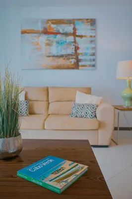 a book sitting on a coffee table in a living room at Tabanka Azul - 2 BdR Cozy and Comfort Apt Near UN in Praia
