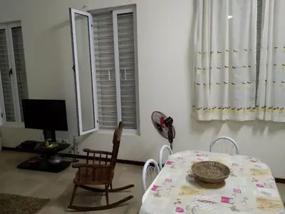 a dining room with a table and chairs and a television at Apartamento T3 em Alto Miramar in Mindelo
