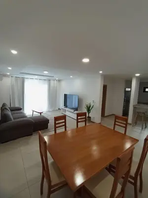 a living room with a wooden table and a couch at o som das ondas in Praia