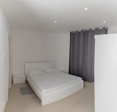 a white bed in a white room with a window at Casa Miranda in Mindelo
