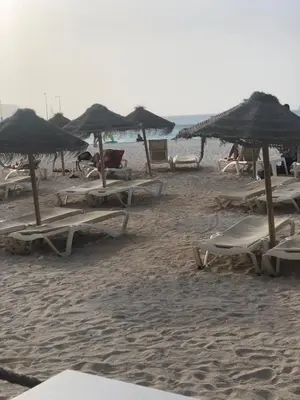 a group of lounge chairs and umbrellas on a beach at Casa Miranda in Mindelo