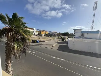 an empty street with a palm tree and a building at Holiday Properties Tropicana in Santa Maria