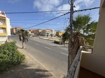 an empty street with palm trees on the side of a building at Holiday Properties Tropicana in Santa Maria