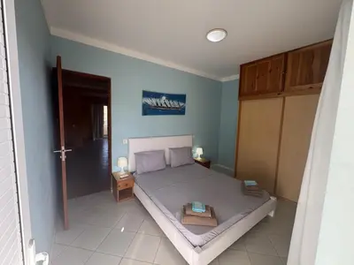 a bedroom with a bed with a table on it at Holiday Properties Tropicana in Santa Maria