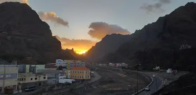a view of a city with the sun setting between two mountains at Casa Nova in Ribeira Grande