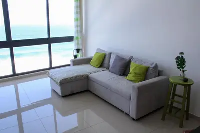 a living room with a couch with green pillows at Casa Nova in Ribeira Grande