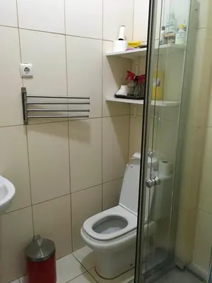 a bathroom with a toilet and a glass shower at Duplex Avenida Ilhéu Santa Maria, Palmarejo in Praia