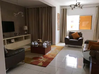 a living room with two couches and a tv at Duplex Avenida Ilhéu Santa Maria, Palmarejo in Praia