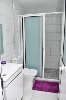 a white bathroom with a toilet and a shower at Modern 2 bedroom apartment in Achada Santo António Praia'' Perto praca Di Nos