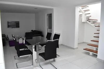 a dining room with a table and black chairs at Modern 2 bedroom apartment in Achada Santo António Praia'' Perto praca Di Nos