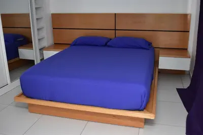 a bedroom with a blue bed with a wooden headboard at Modern 2 bedroom apartment in Achada Santo António Praia'' Perto praca Di Nos