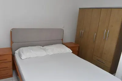 a bedroom with a white bed and wooden cabinets at Modern 2 bedroom apartment in Achada Santo António Praia'' Perto praca Di Nos