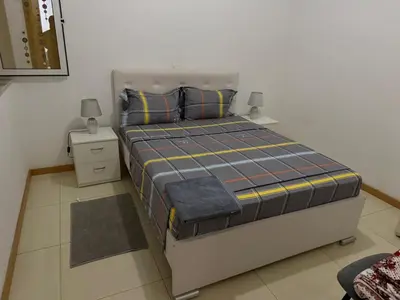 a bedroom with a large bed with two night stands at Gamboa t2 in Praia
