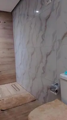 a bathroom with a marble wall with a toilet at Sal Blue Apartment in Santa Maria