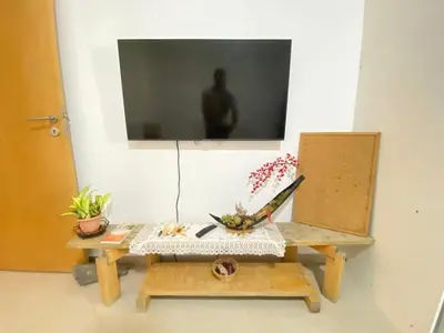 a room with a table and a tv on a wall at Guest house B&S in Praia