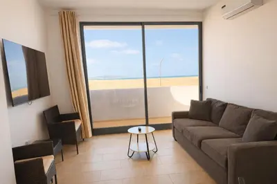 a living room with a couch and a table at JoLi Beach Apartments with Shared Pool in Santa Maria