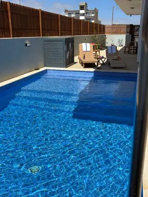 a large swimming pool with blue water in it at JoLi Beach Apartments with Shared Pool in Santa Maria