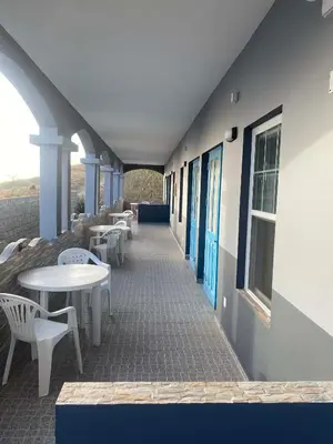 a corridor of a building with tables and chairs at Djabraba's Hiker's Suite in Garça