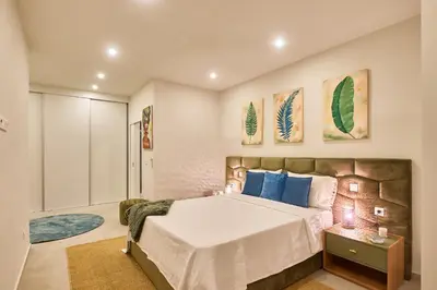 a bedroom with a large bed with blue pillows at Sal Sol & Mar - Larimar in Santa Maria
