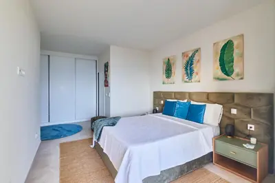 a bedroom with a large bed with blue pillows at Sal Sol & Mar - Larimar in Santa Maria