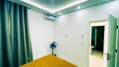 a room with a green curtain and a fan at Prestige Apartment in Praia