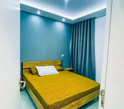 a bedroom with a bed with a blue wall at Prestige Apartment in Praia