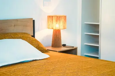 a bedroom with a bed with a lamp on a night stand at Prestige Apartment in Praia