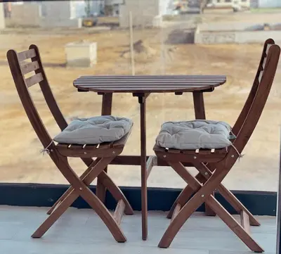 a wooden table and two chairs next to a window at T1 Espaçoso e aconchegante no Medsal Residence in Prainha