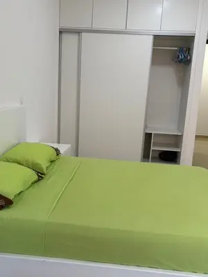 a bedroom with a green bed and a white cabinet at Apartamento Teixeira 2 in Espargos