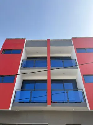 a red and white building with blue windows at Apartamento Teixeira 2 in Espargos