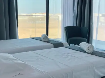 two beds in a hotel room with a view of an airport at T1 panorâmico no Medsal Residence in Santa Maria