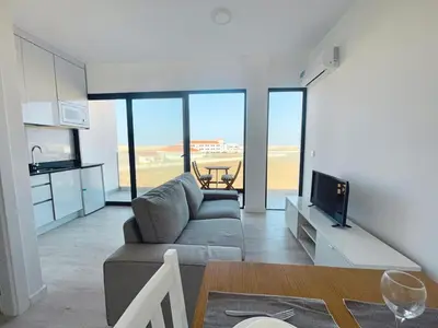 a living room with a couch and a television at T1 panorâmico no Medsal Residence in Santa Maria