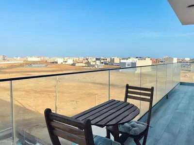 a wooden bench sitting on a balcony looking at an airport at T1 panorâmico no Medsal Residence in Santa Maria