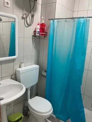 a bathroom with a blue shower curtain and a toilet at Prédio IFH in Vila do Maio