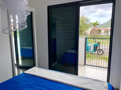 a bedroom with a window with a bed and a balcony at Casa Uta in Tarrafal