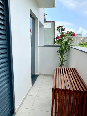 a wooden bench sitting on a balcony with a plant at Casa Uta in Tarrafal