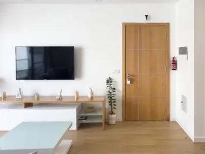 a living room with a tv and a wooden door at Cozy 1-bdr apt, Cidadela - LCGR in Praia