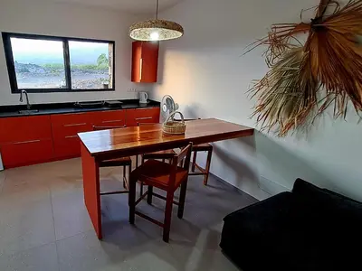 a kitchen with a wooden table and a chair at Kasa surf in Porto Novo