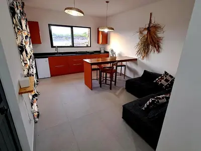 a living room and kitchen with a table and a couch at Kasa surf in Porto Novo