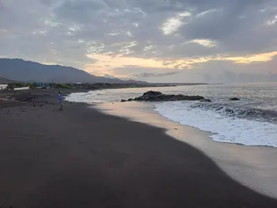a person standing on a beach near the ocean at Kasa surf in Porto Novo