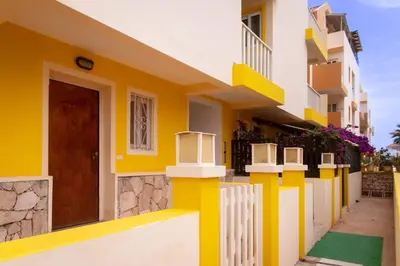 a house with yellow and white walls and a door at Flat 4U in Santa Maria
