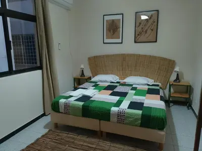 a bedroom with a bed with a colorful quilt on it at Essencia Sterra in Praia
