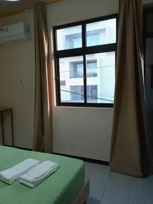 a bedroom with a window and a bed with two towels at Essencia Sterra in Praia